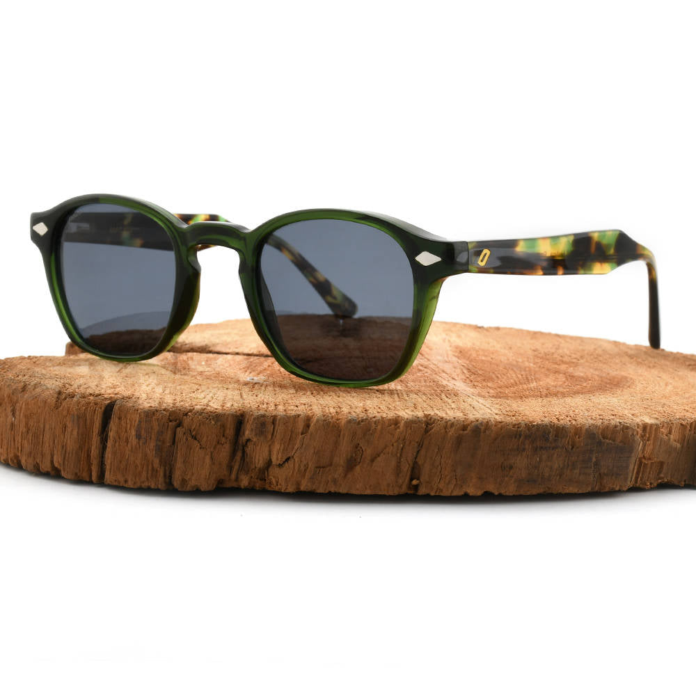 Sunglasses with green frame and dark lenses on a wooden surface